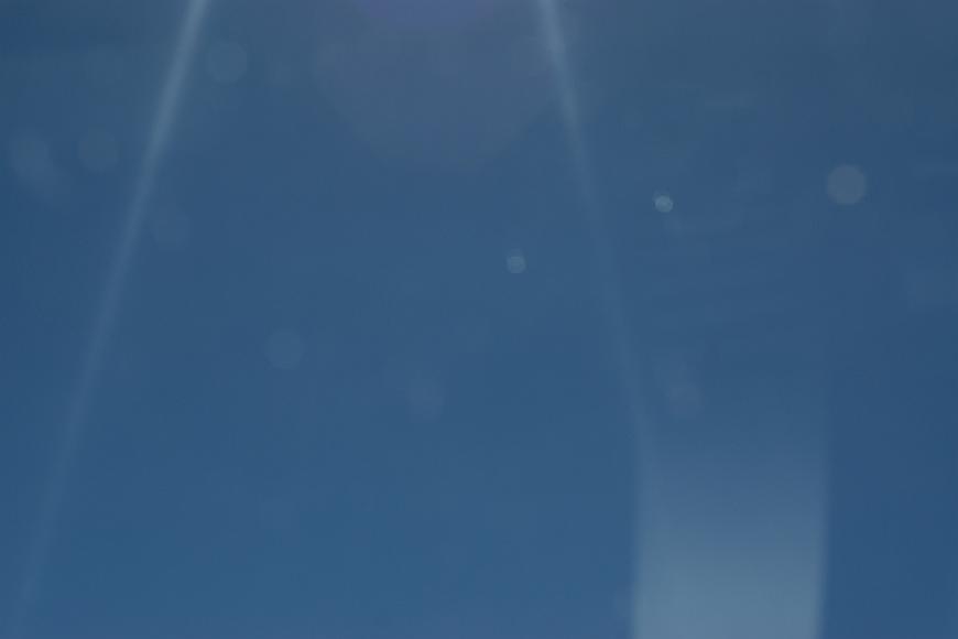 Blue sky #1 speck on lens flare against a medium blue sky