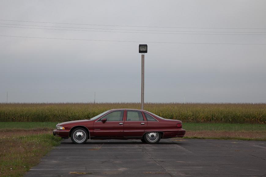 Maroon Chevy Caprice Classic in front of a corn field in Kansas