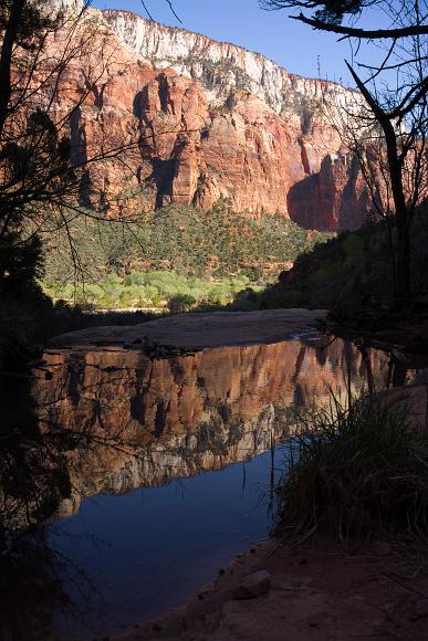 Reflecting Pool in Zion National Park red and white and yellow sandstone rocks reflected in small still water puddle