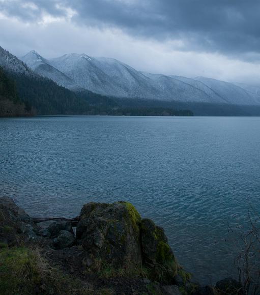 The snowline drops almost to sea level on Crescent Lake, Olympic Peninsula, Washington Mountains in the background, covered with snow almost to the bottom, with a clearly delineated snow line about 100ft up the mountains, Crescent lake in the...