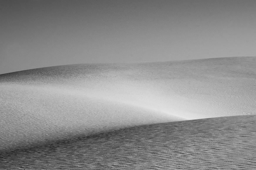 White Sands 2012 14 Black and White gypsum sand dunes underneath with sunlit ripples in the foreground fading to shaded ripples and sunlight elsewhere in White Sands National...